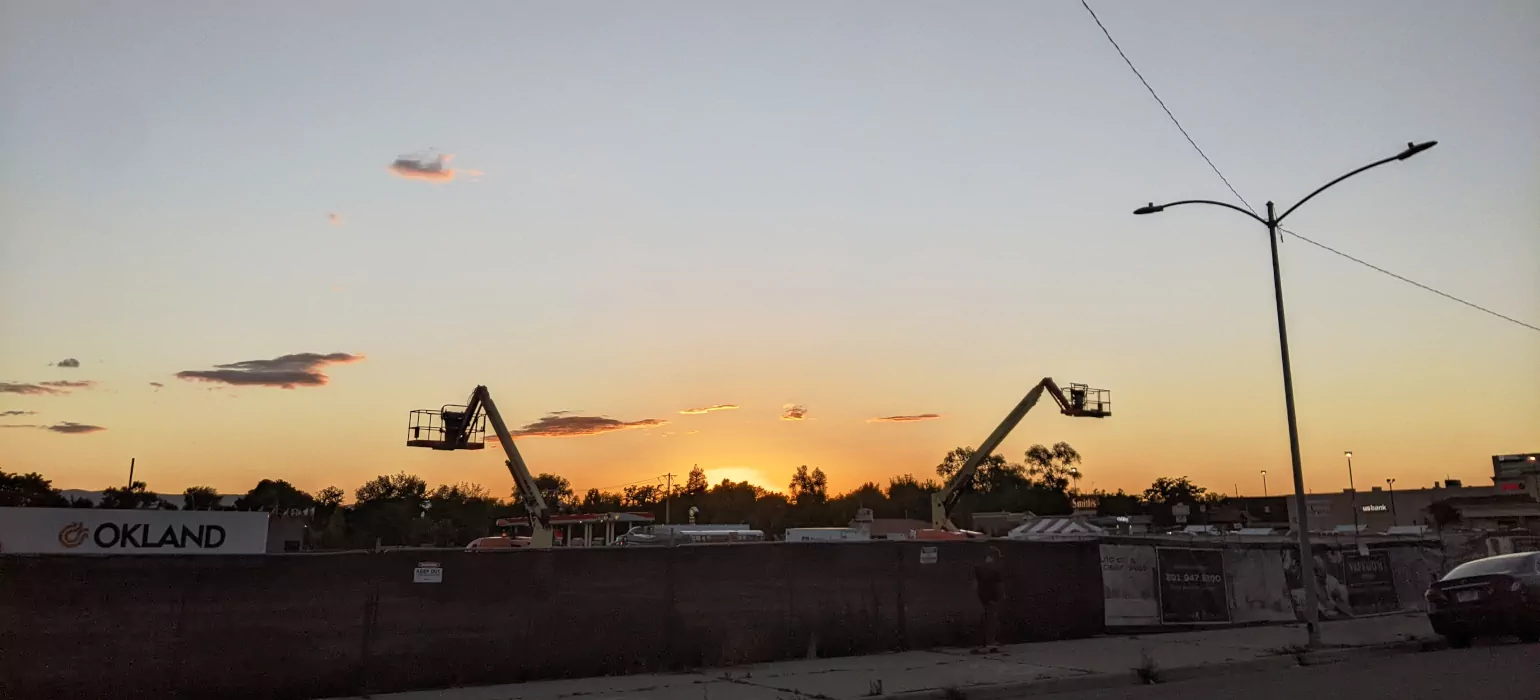 A sunset with silhouetted construction equipment